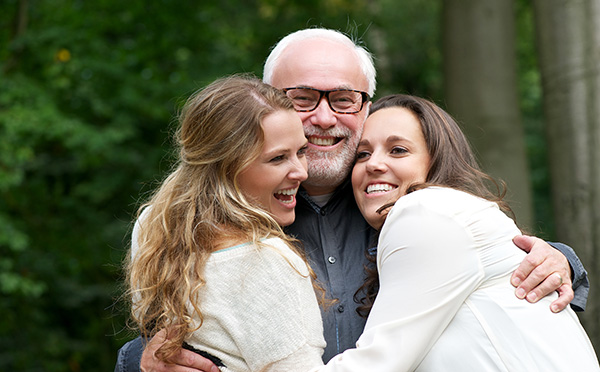 Father smiling with daughters